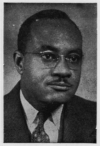 Studio portrait of a middle-aged African American man with a thin mustache wearing glasses, a suit jacket, dress shirt and tie.